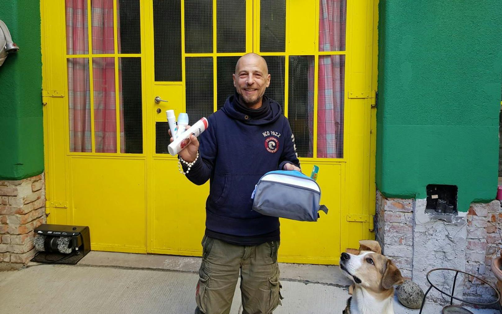 Der Projektleiter des Verein MUT Alex Maier (51) zeigt die Hygienetaschen für Obdachlose. Hund Aaron schaut darauf, dass alles vollständig ist. (c) Louis Kraft