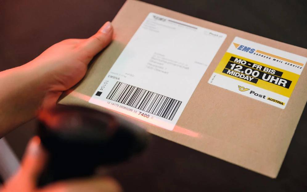 Ein Postpaket wird eingescannt. Symbolbild