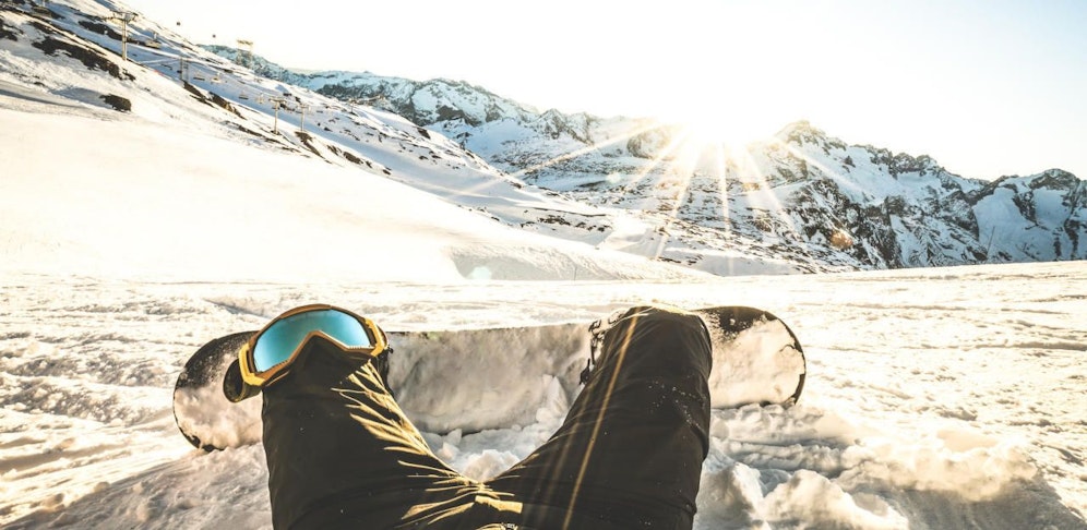 Symbolfoto eines Snowboarders bei Sonnenuntergang