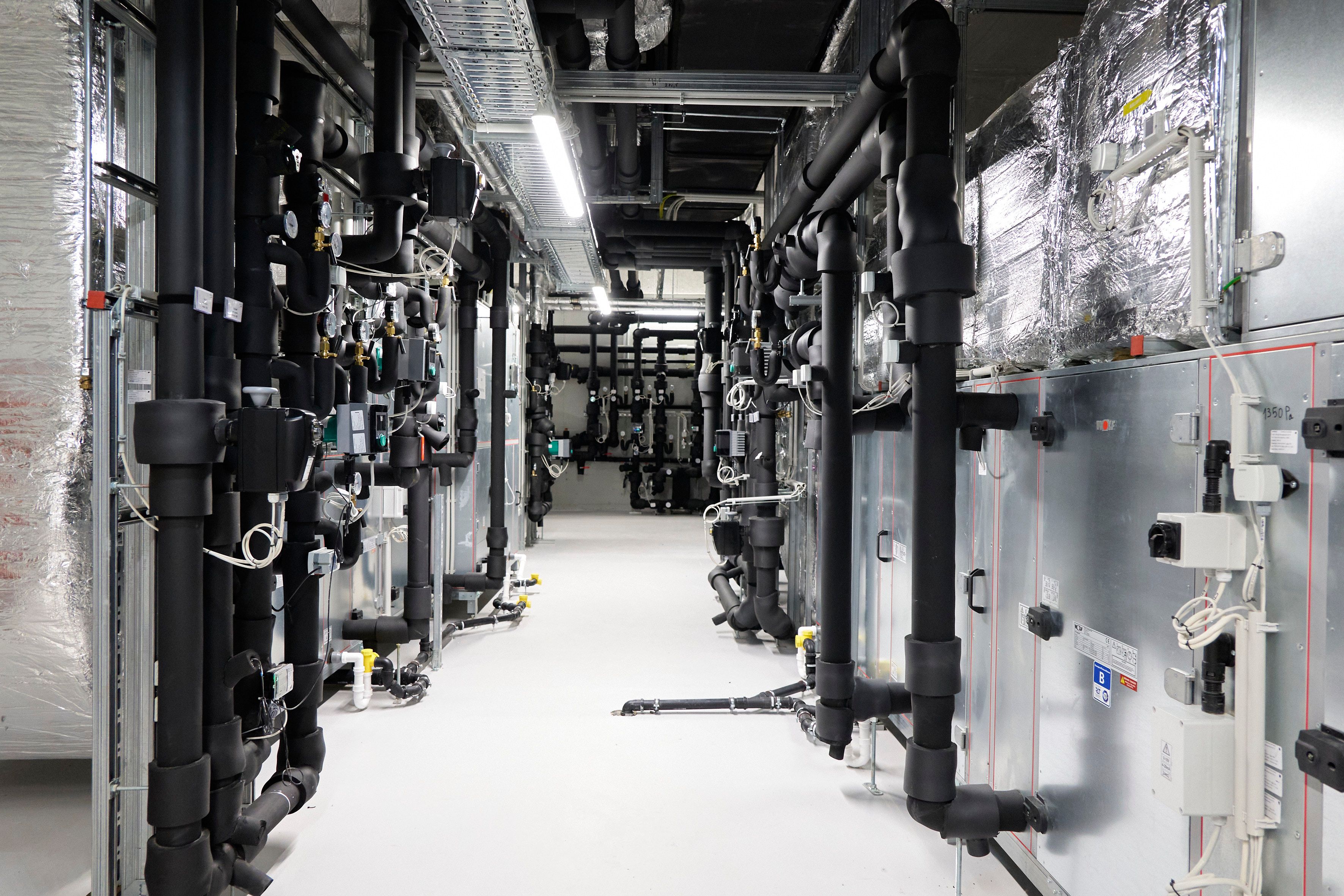 Während ab Herbst 2021 oben rund 1.100 Kinder und Jugendliche lernen und spielen, kümmert sich die Haustechnik um eine klimafreundliche und angenehme Atmosphäre. Durch den Einsatz von Wärmepumpen und Photovoltaik versorgt sich das Gebäude selbst mit Energie.