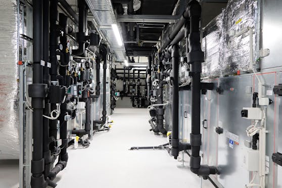 Während ab Herbst 2021 oben rund 1.100 Kinder und Jugendliche lernen und spielen, kümmert sich die Haustechnik um eine klimafreundliche und angenehme Atmosphäre. Durch den Einsatz von Wärmepumpen und Photovoltaik versorgt sich das Gebäude selbst mit Energie.