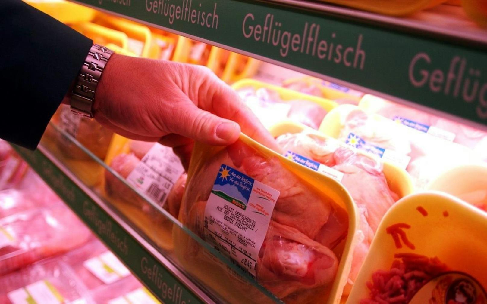 Ein Kunde stöbert durch verpacktes Hühnerfleisch in einem Supermarkt. Symbolfoto