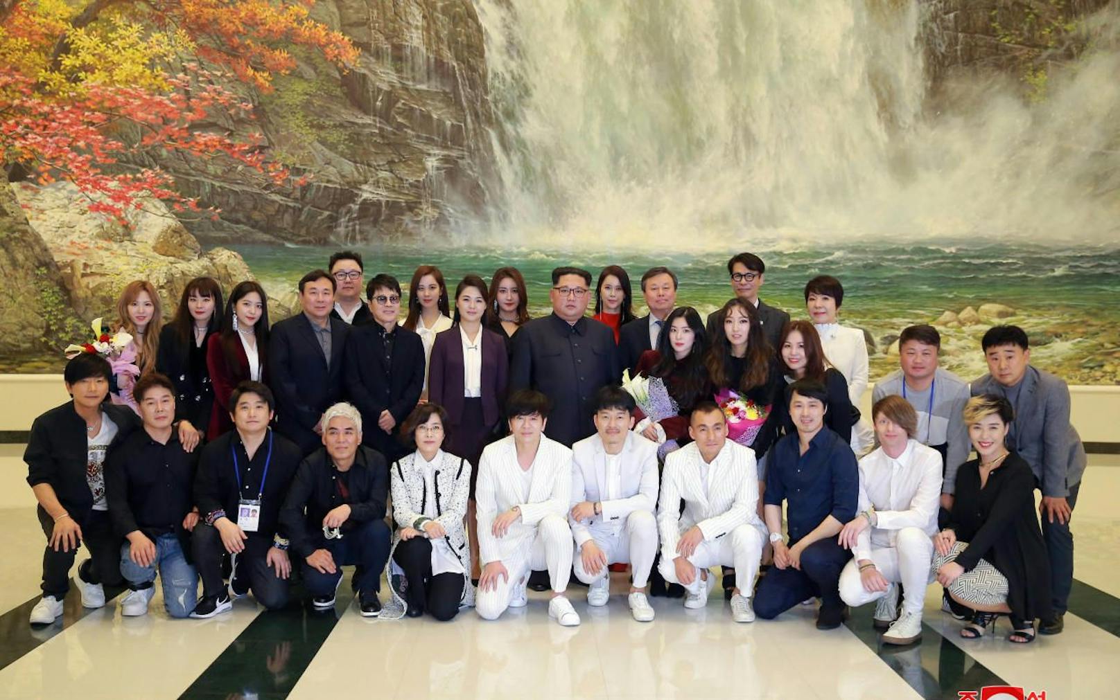 Gruppenbild mit Diktator: Kim Jong-un (Mitte, er freut sich nach innen) mit Ehefrau, Darstellern und Musikern des zweistündigen Popkonzerts. 