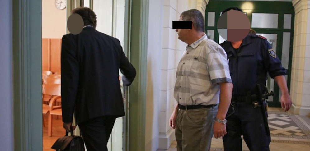 Der Angeklagte (Mi.) am Weg in den Gerichtssaal.