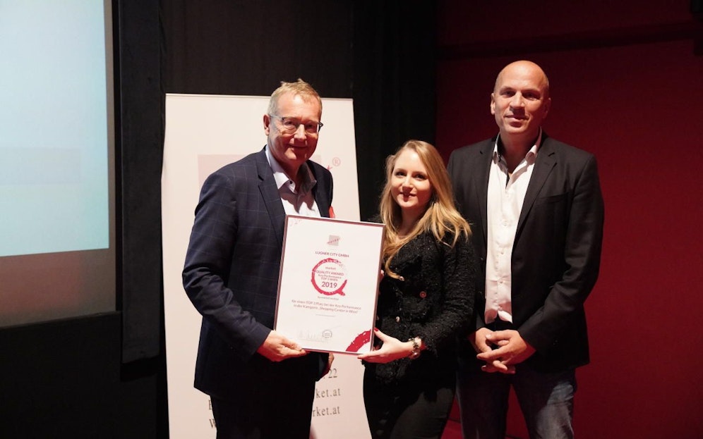 Die Lugner City holt sich im Ranking der Wiener Shopping Center "Bronze" und erhält den "market Quality Award 2019": (v.l.n.r.) market Institutsvorstand Werner Beutelmeyer übergibt den Preis an Jacqueline Lugner und Lugner City-Geschäftsführer Gerald Friede.                             