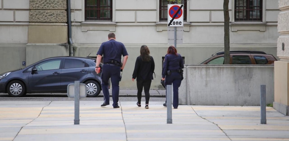 Die Angeklagte (Mi.) mit Justizwachebeamten.