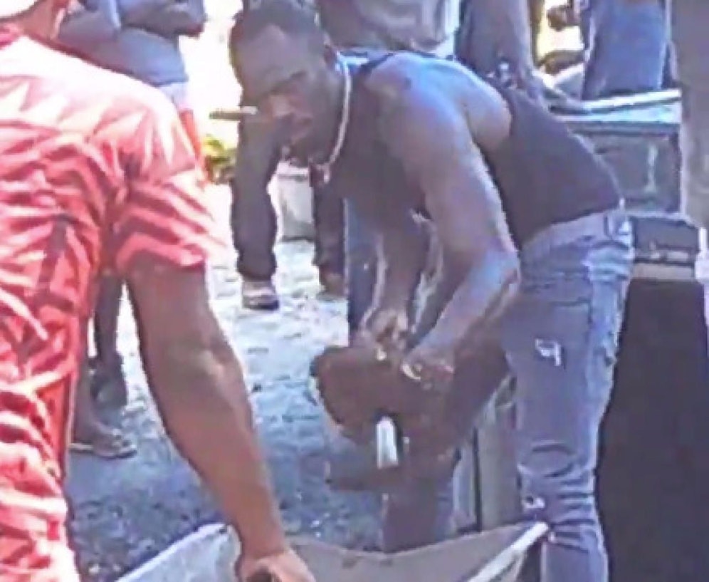 Usain Bolt hebt das Grab für Germaine Mason aus.