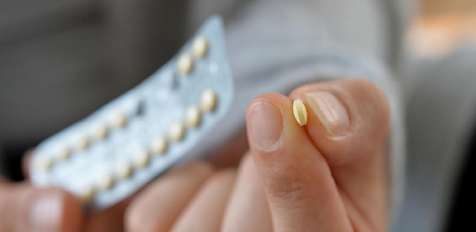 Eine Frau hält eine Packung der Antibabypille in der Hand. 