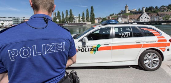 Ein Polizist aus Schaffhausen (Schweiz) neben einem Streifenwagen. Symbolfoto