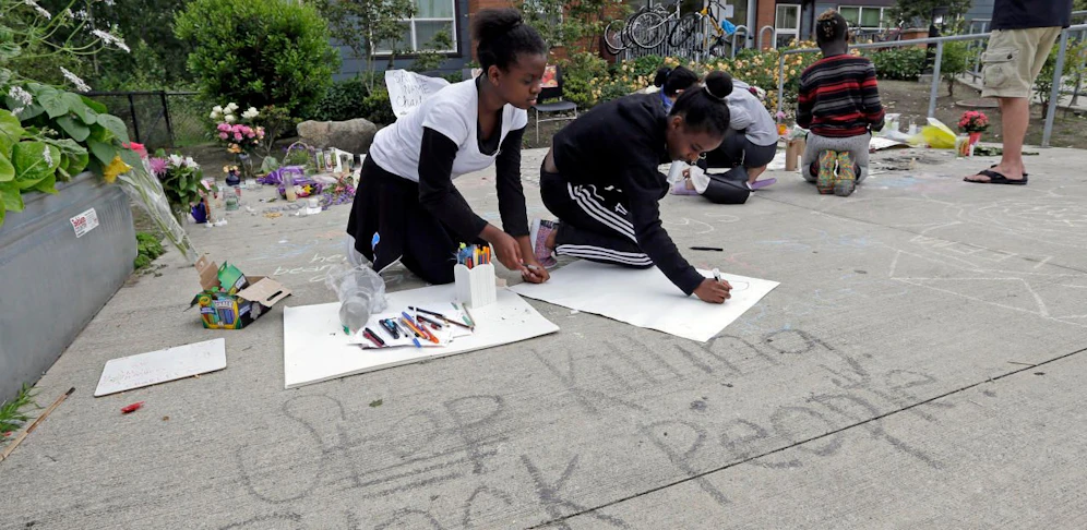 Kinder schreiben die Worte "Stop Killing Black People" auf die Straße