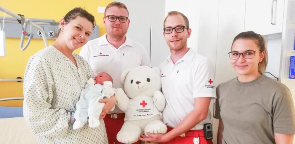 Die stolze Mutter und Baby Norbert bekamen von Rettungssanitäter Kevin Bauer, Notfallsanitäter Patrick Wölfer und Lea Müller einen RK-Bären geschenkt.