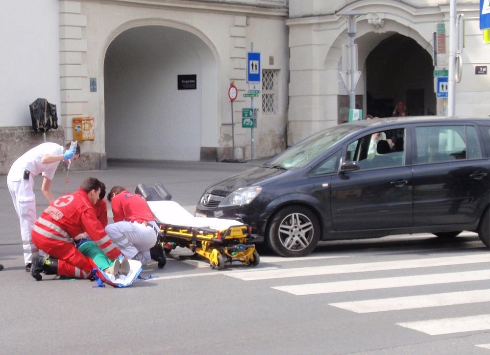 Rettungskräfte versorgen eine verletzte Person nach einem schweren Verkehrsunfall mitten in der Stadt.