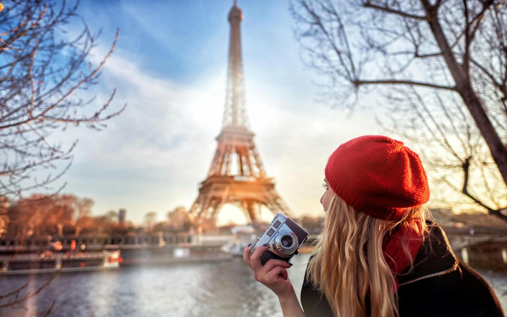 traveling and lifestyle concept.tourist woman with red beret admiring the Eiffel tower and holding camera in her hand.