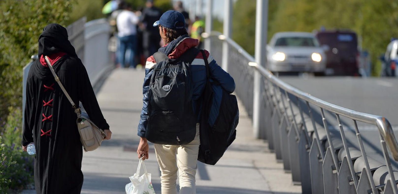 Flüchtlinge gehen in kleineren Gruppen zu Fuß von Salzburg in Richtung Grenzübergang Freilassing.