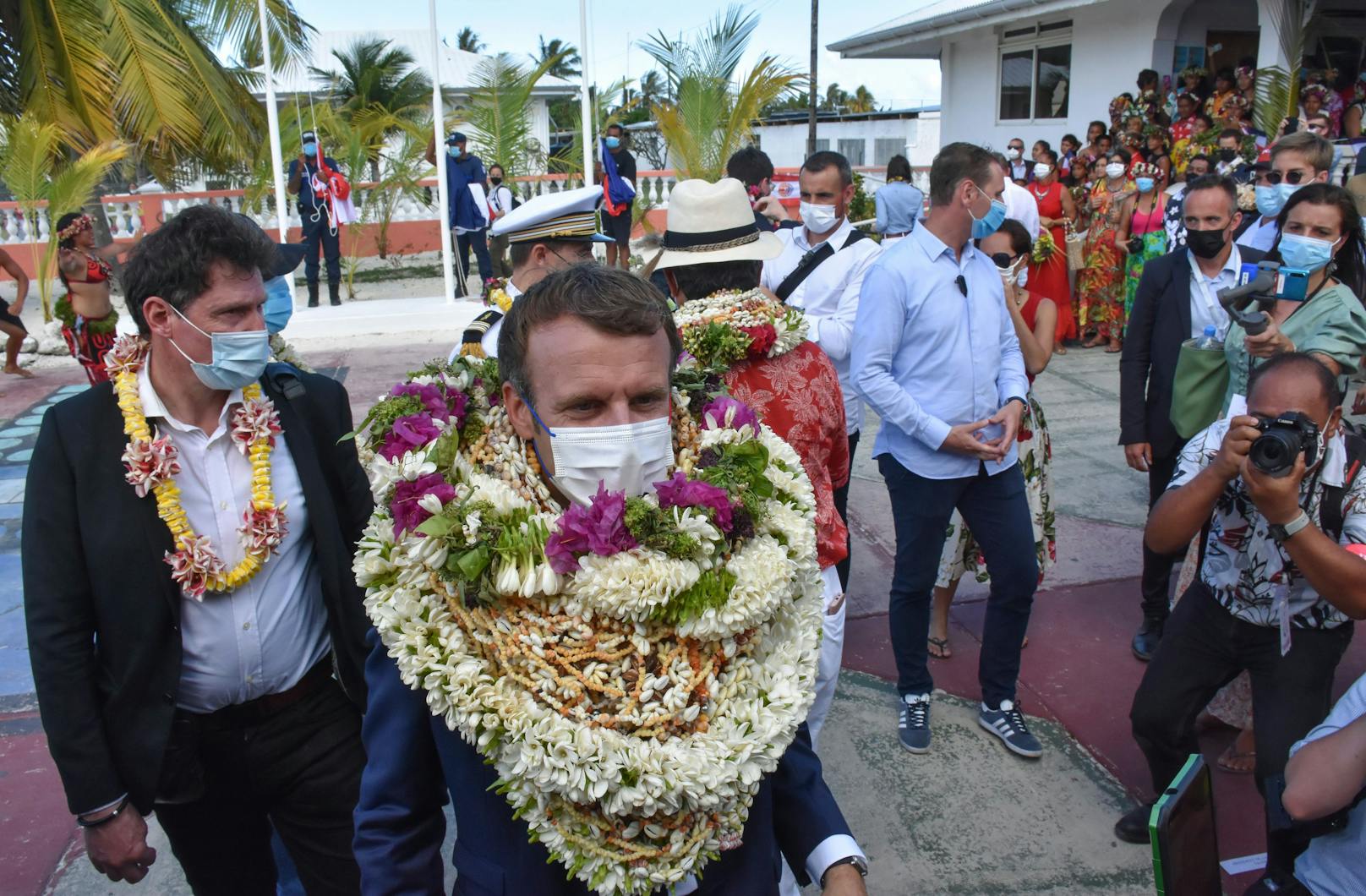 Emmanuel Macron wurden als Willkommensgeste Blumenkränze und Muscheln umgehängt.