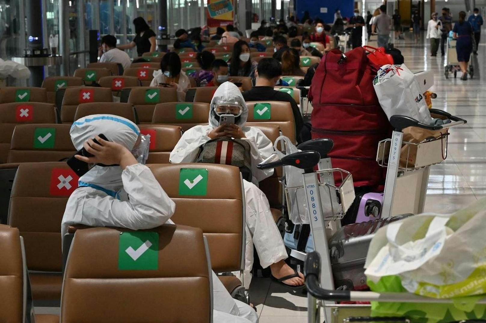 Schutzanzüge gehören mittlerweile zum Alltag: Passagiere am internationalen Suvarnabhumi Airport in Bangkok. Mittlerweile sind alle Inlandsflüge gestrichen.