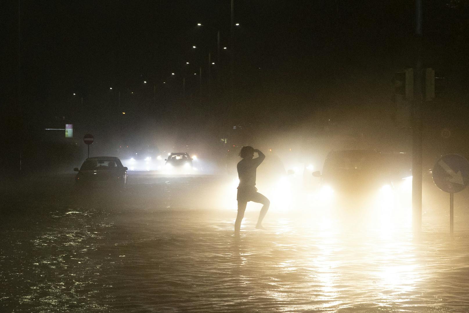 Eine Person tanzt auf einer überfluteten Kreuzung nach schweren Unwettern am Freitag, 30. Juli 2021, in Graz.
