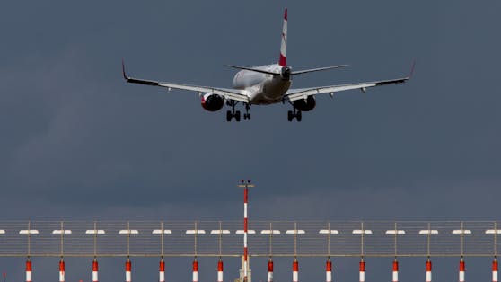 Eine Bombardier Embraer 195 der Austrian Airlines während des Landeanflugs bei Sturm und dunklen Wolken. Symbolbild