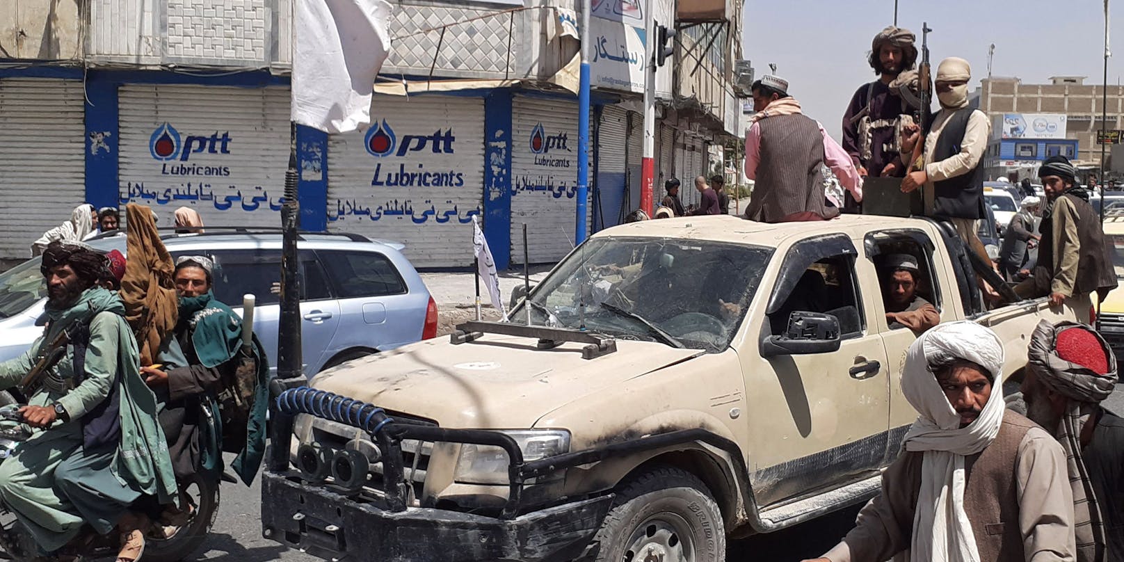 Taliban-Kämpfer mit einem erbeuteten Fahrzeug der afghanischen Armee