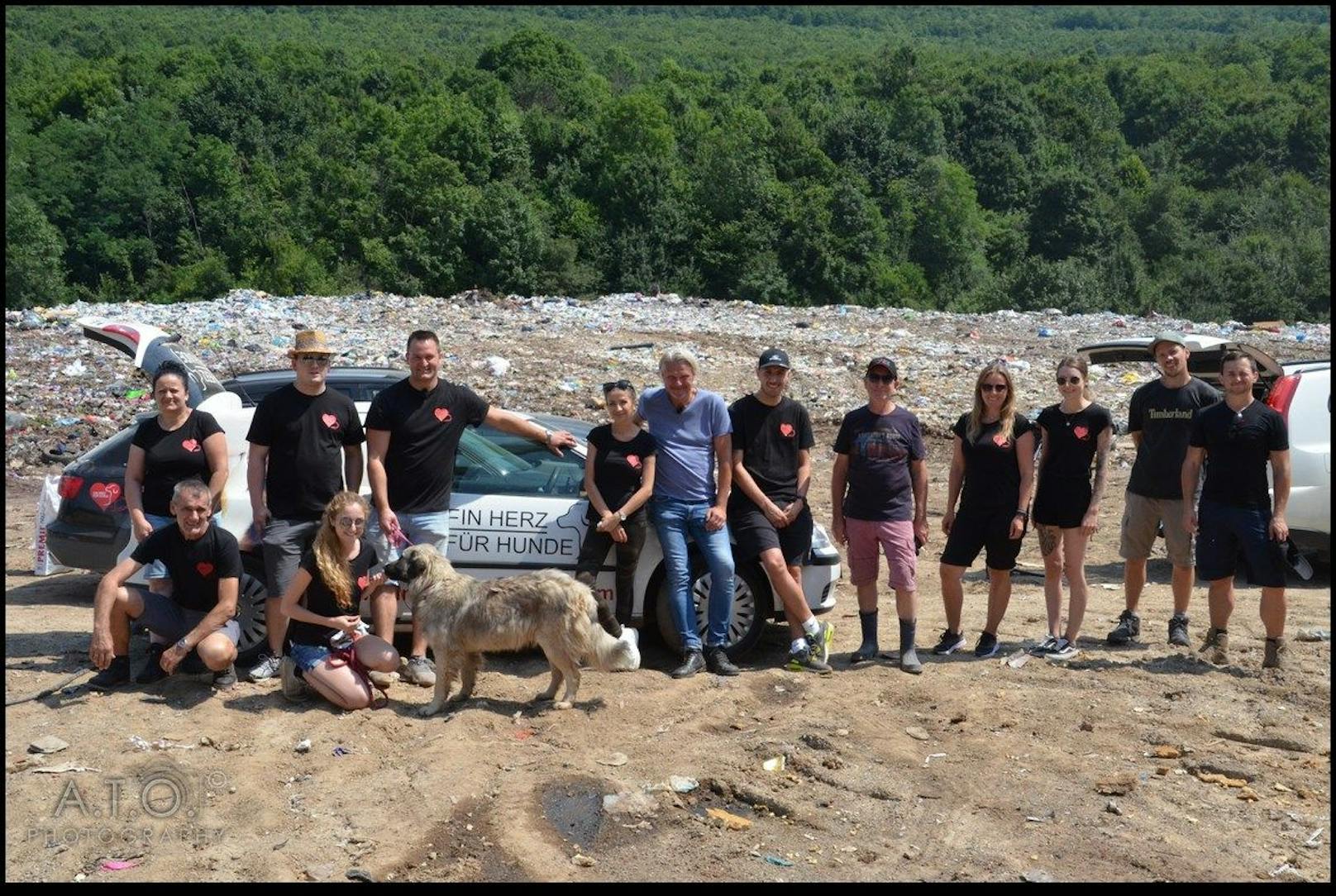 Ein Berg aus Müll und davor eine ganze Gruppe von ehrenamtlichen Helfen mit einem großen Herz für Hunde.
