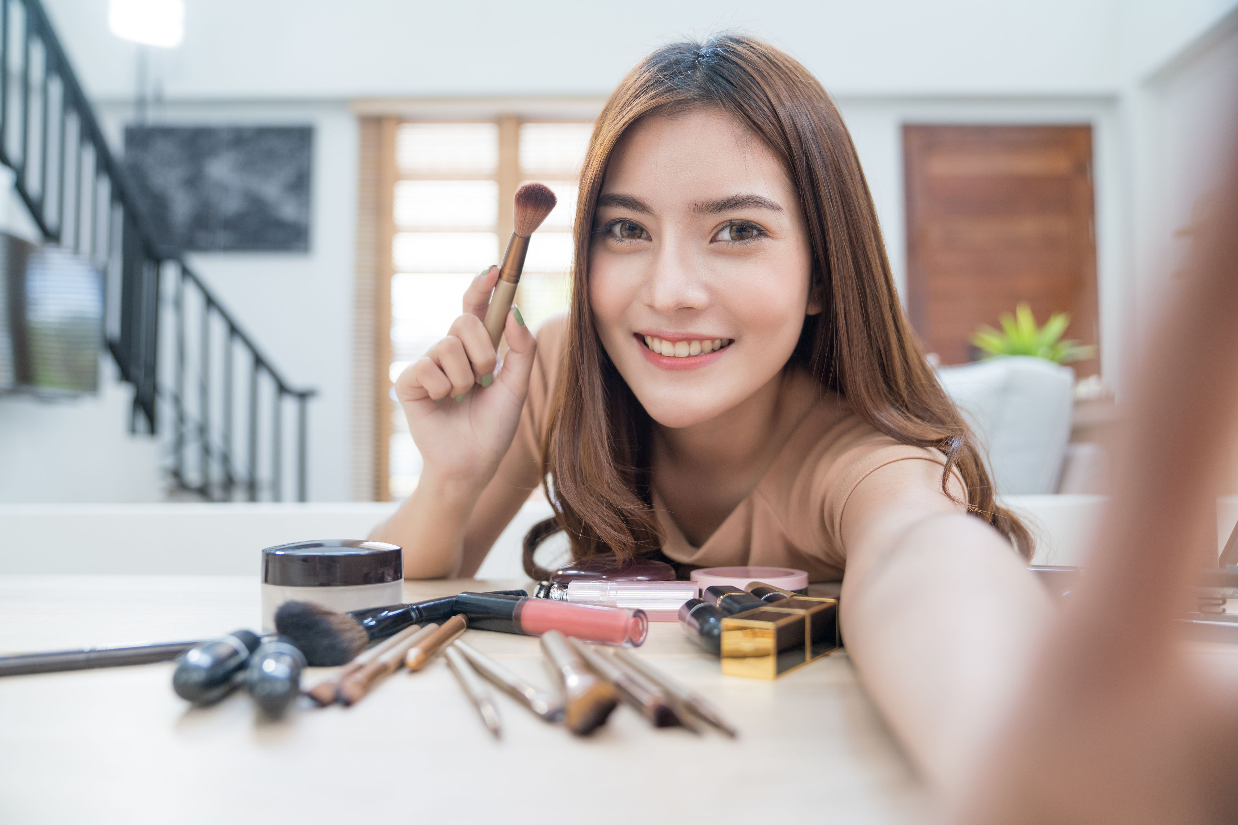 Young beautiful asian woman professional beauty vlogger or blogger recording make up tutorial to share on social media