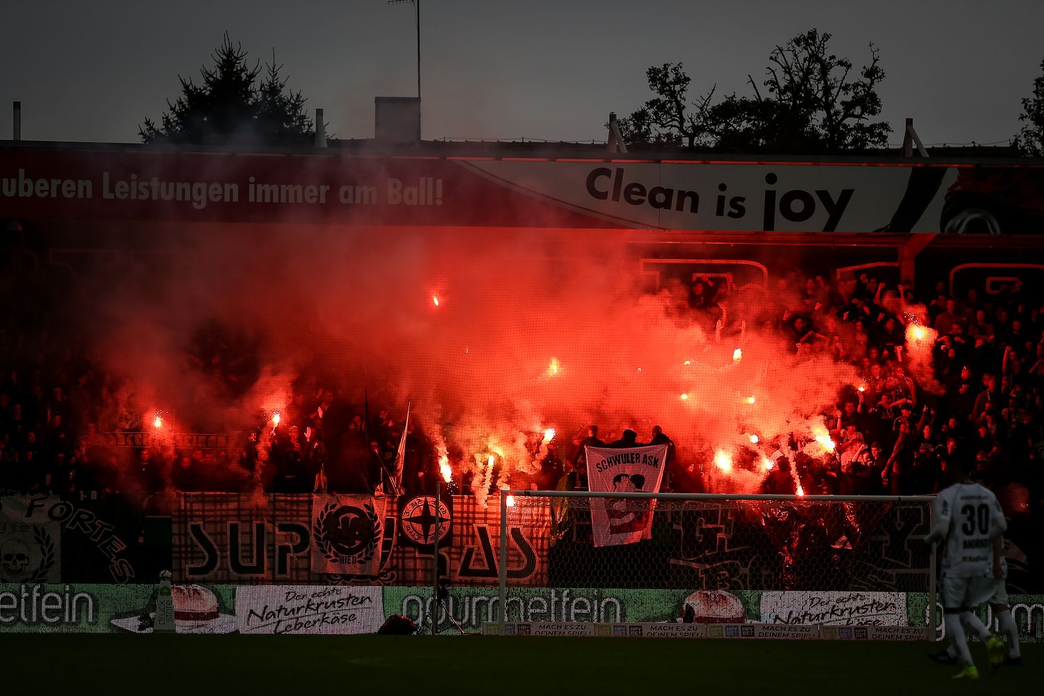Pyrotechnik und ein homophobes Plakat im Ried-Fansektor.