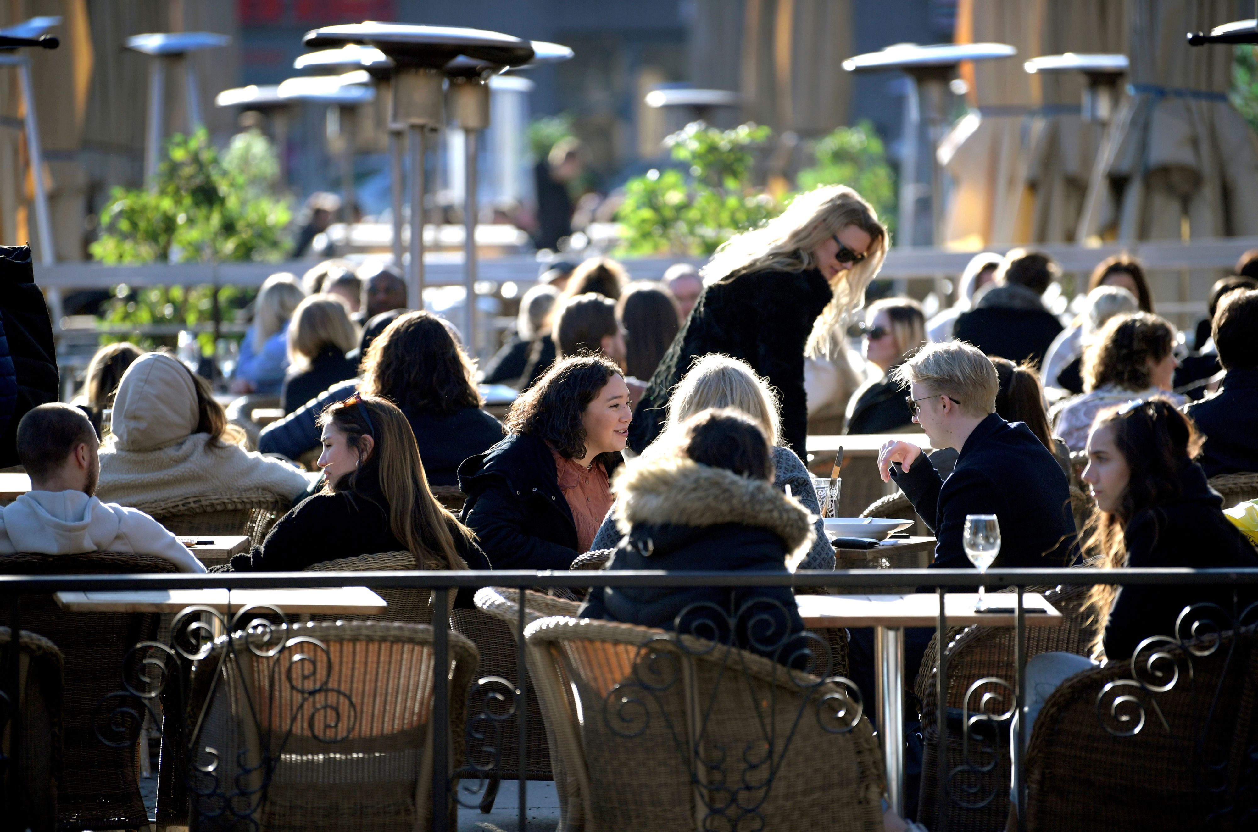 FILE PHOTO: People enjoy the sun at an outdoor restaurant, despite the continuing spread of coronavirus disease (COVID-19), in Stockholm, Sweden March 26, 2020. TT News Agency/Janerik Henriksson via REUTERS      ATTENTION EDITORS - THIS IMAGE WAS PROVIDED BY A THIRD PARTY. SWEDEN OUT. NO COMMERCIAL OR EDITORIAL SALES IN SWEDEN./File Photo