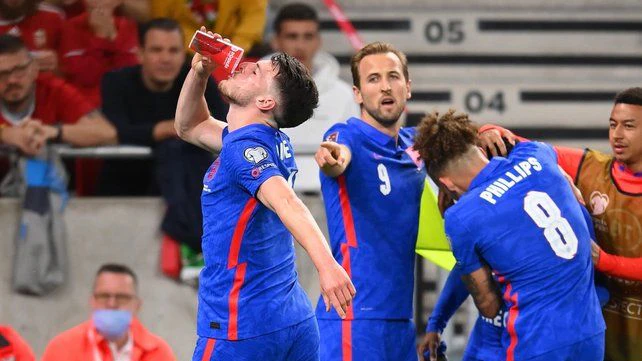 Declan Rice trinkt aus einem Becher, der aufs Feld geflogen kam. 