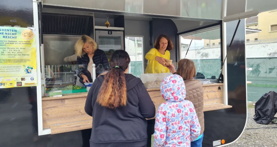 Das Team von Foodtruck-gemeinsam satt sein gibt Essen im Sonnenpark aus.