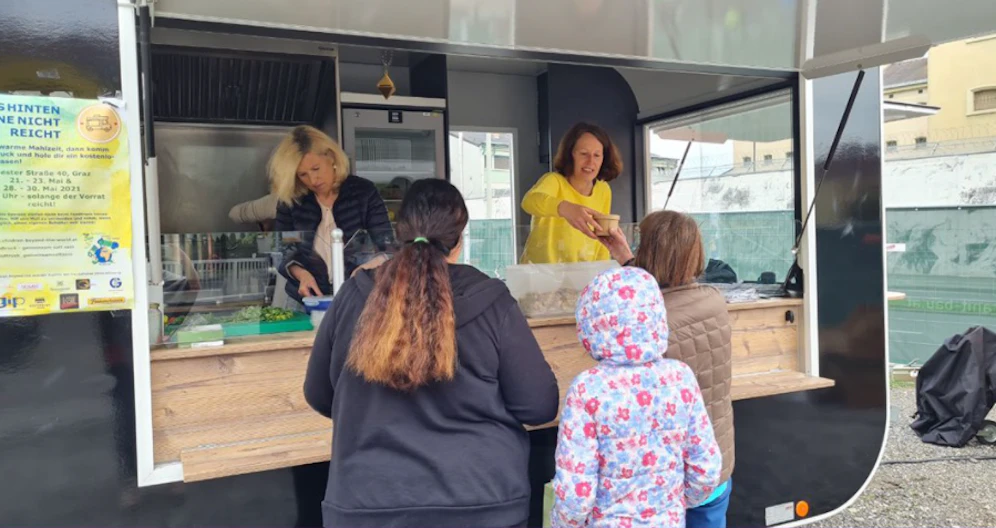 Das Team von Foodtruck-gemeinsam satt sein gibt Essen im Sonnenpark aus.