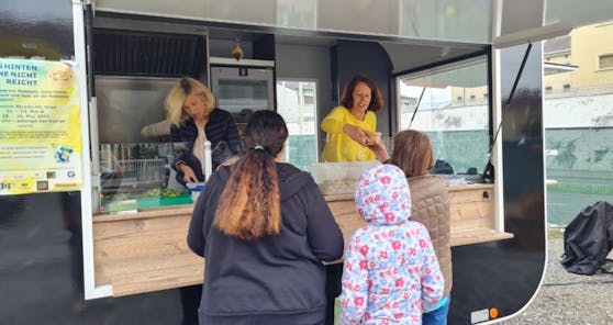 Das Team von Foodtruck-gemeinsam satt sein gibt Essen im Sonnenpark aus.