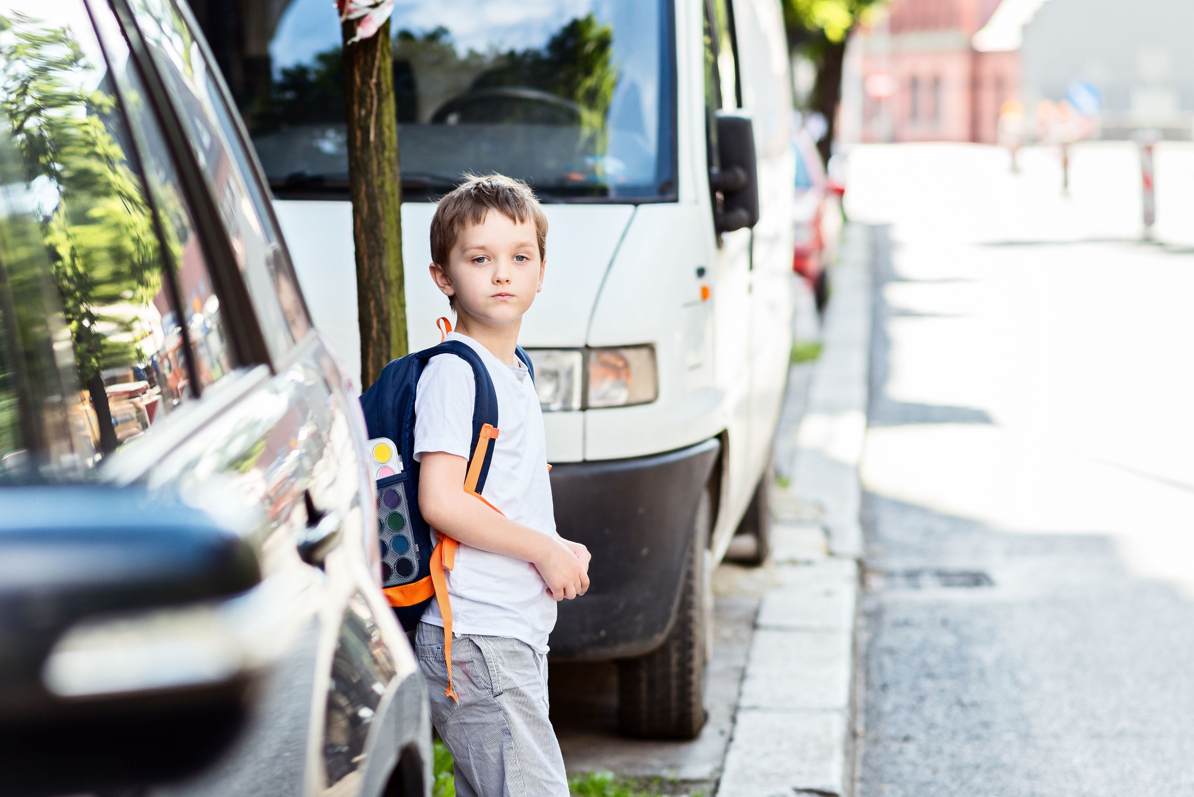 Little schoolboy waiting for the opportunity to move to the other side of the street. Road to school