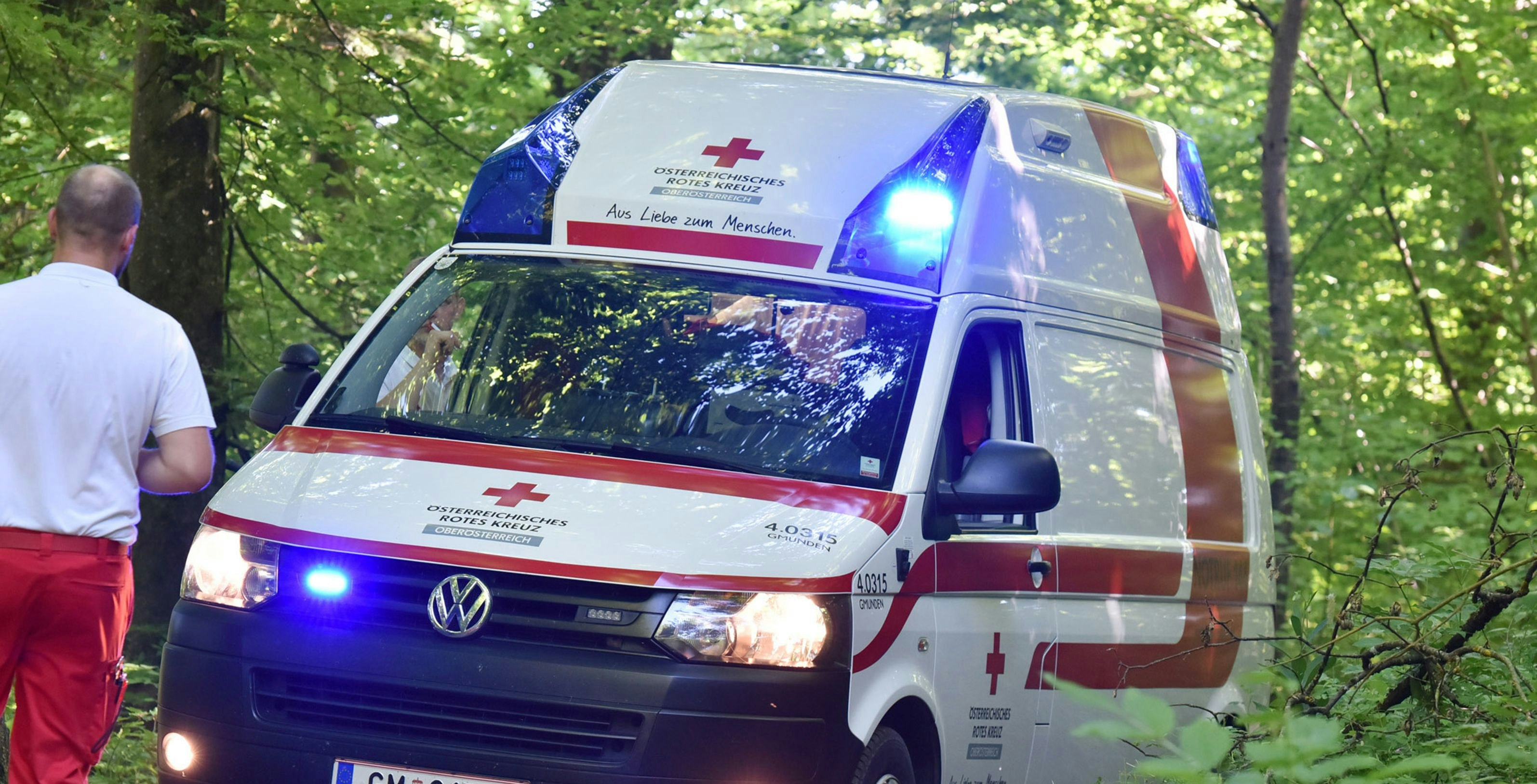 A red cross ambulance with blue lights in a wood, Austria, Europe