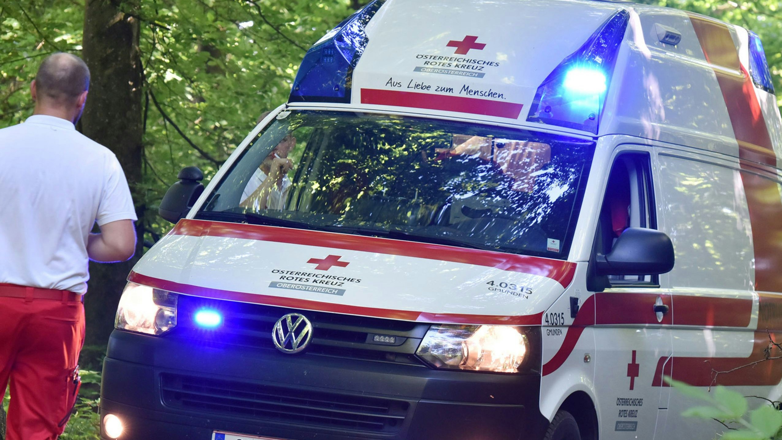 A red cross ambulance with blue lights in a wood, Austria, Europe