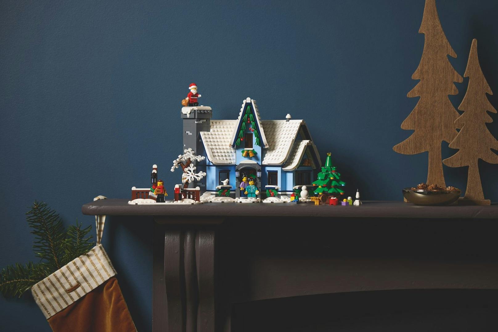 Der Mittelpunkt des "LEGO Besuch vom Weihnachtsmann"-Sets ist ein mit Stechpalmenzweigen geschmücktes kleines Häuschen mit verschneitem Tor samt Briefkasten. 