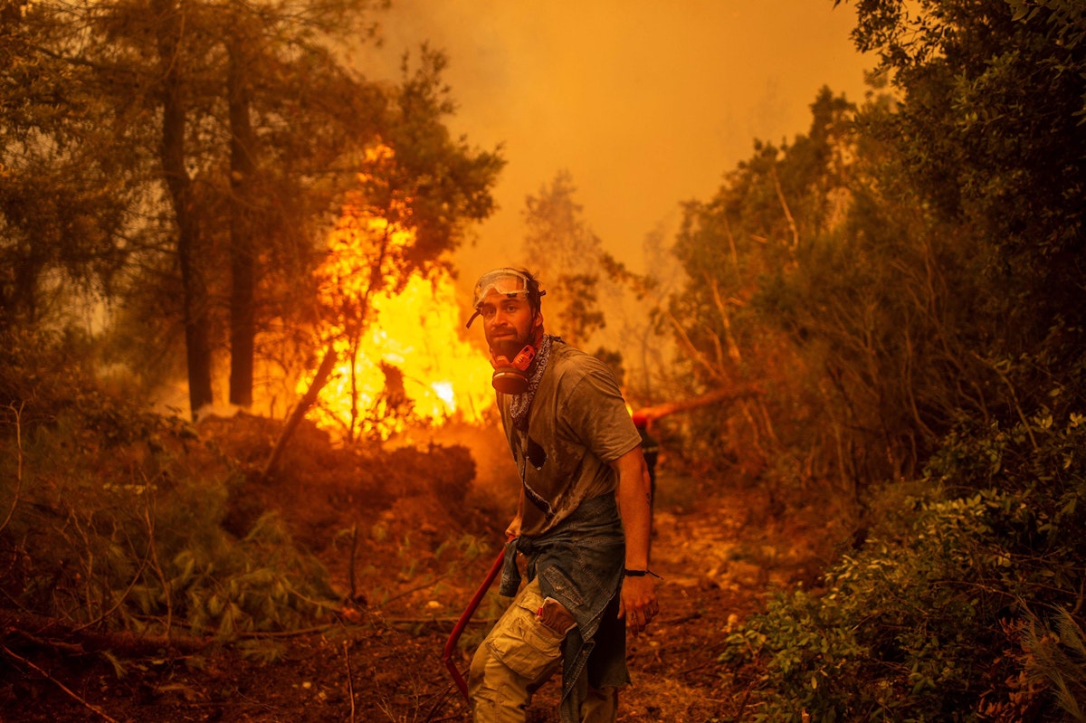 Download von www.picturedesk.com am 13.09.2021 (14:29).  TOPSHOT - A volunteers holds a water hose near a burning blaze as he tries to extinguish a fire in the village of Glatsona on Evia (Euboea) island, on August 9, 2021. - Firefighters tried on August 9, to prevent fires from reaching key communities and a thick forest that could fuel an inferno that one official said has destroyed hundreds of homes in seven days on the Greek island of Evia. If most of nearly two weeks of fires had stabilised or receded in other parts of Greece, the ones on rugged and forested Evia were the most worrying and created apocalyptic scenes. (Photo by ANGELOS TZORTZINIS / AFP) - 20210809_PD3646 - Rechteinfo: Rights Managed (RM) Nur für redaktionelle Nutzung! Werbliche Nutzung erfordert Freigabe: bitte schicken Sie uns eine Anfrage.