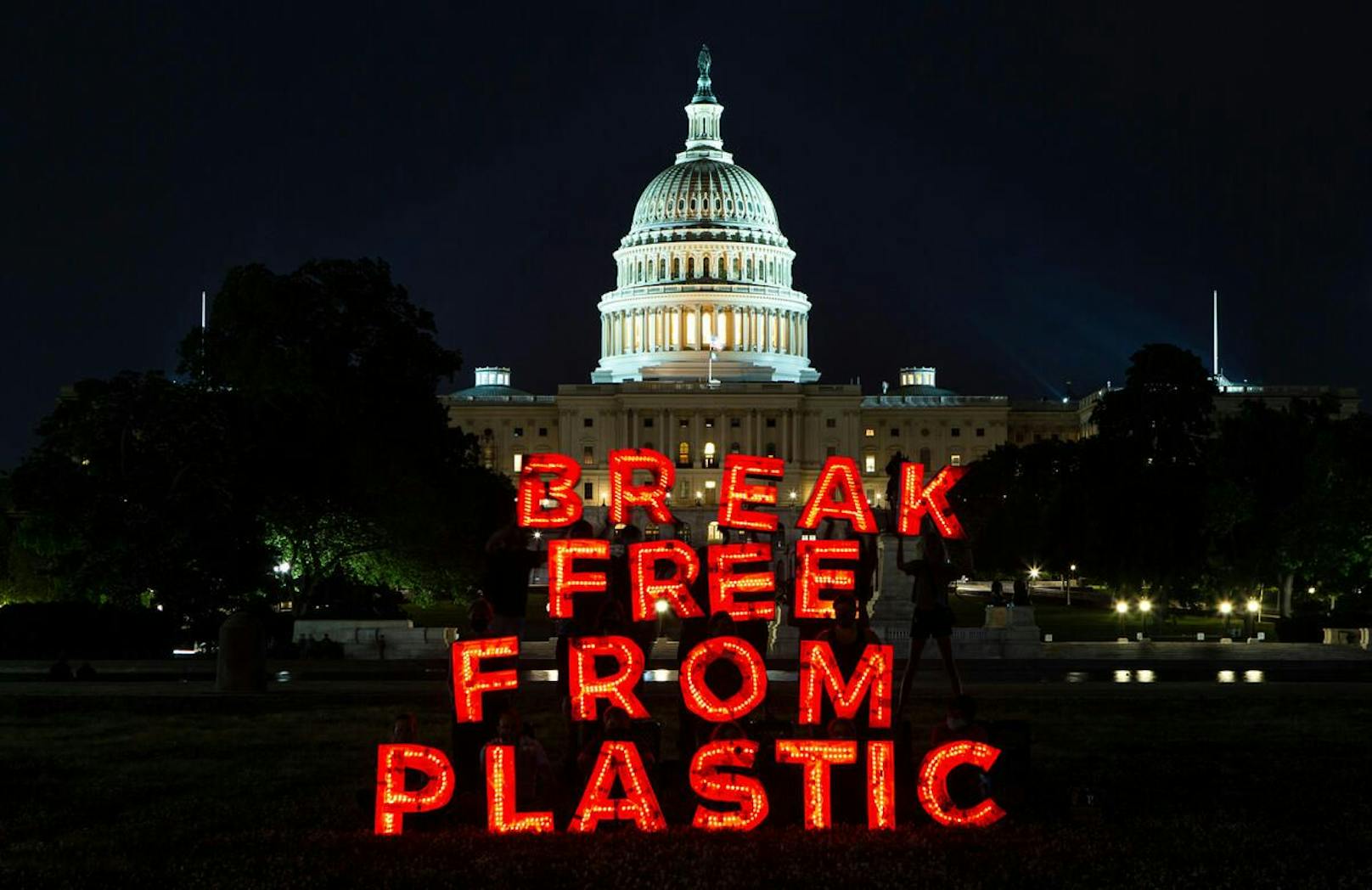 Die Nachricht "Befreien wir uns von Plastik" erhellt die Nacht in der Nähe des US-Kapitols in Washington. Konzerne treiben die Krise der Plastikverschmutzung massiv voran. Coca-Cola, PepsiCo und Nestle gehören zu den weltweit größten Umweltverschmutzern.<br>