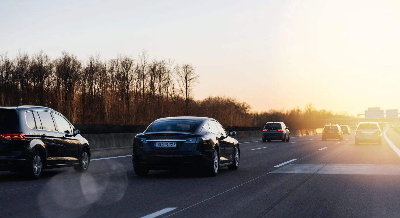 Offenburg: Tesla P85 and Multiple cars driving on the winter evening on the German Autobahn with the direction Offenburg, Basel, Frankfurt with beautiful sunset and sun flare