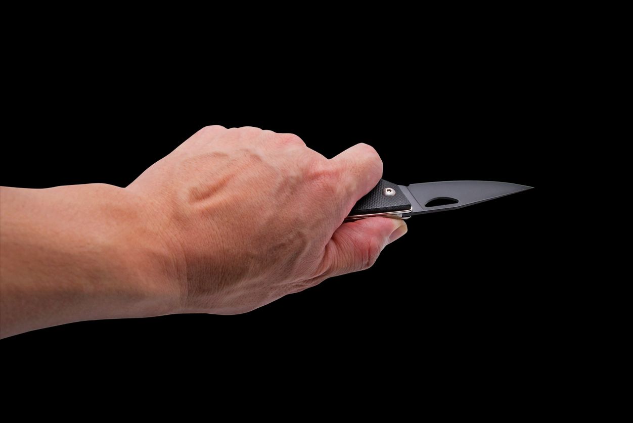 Hand holding Penknife Isolated on Black Background