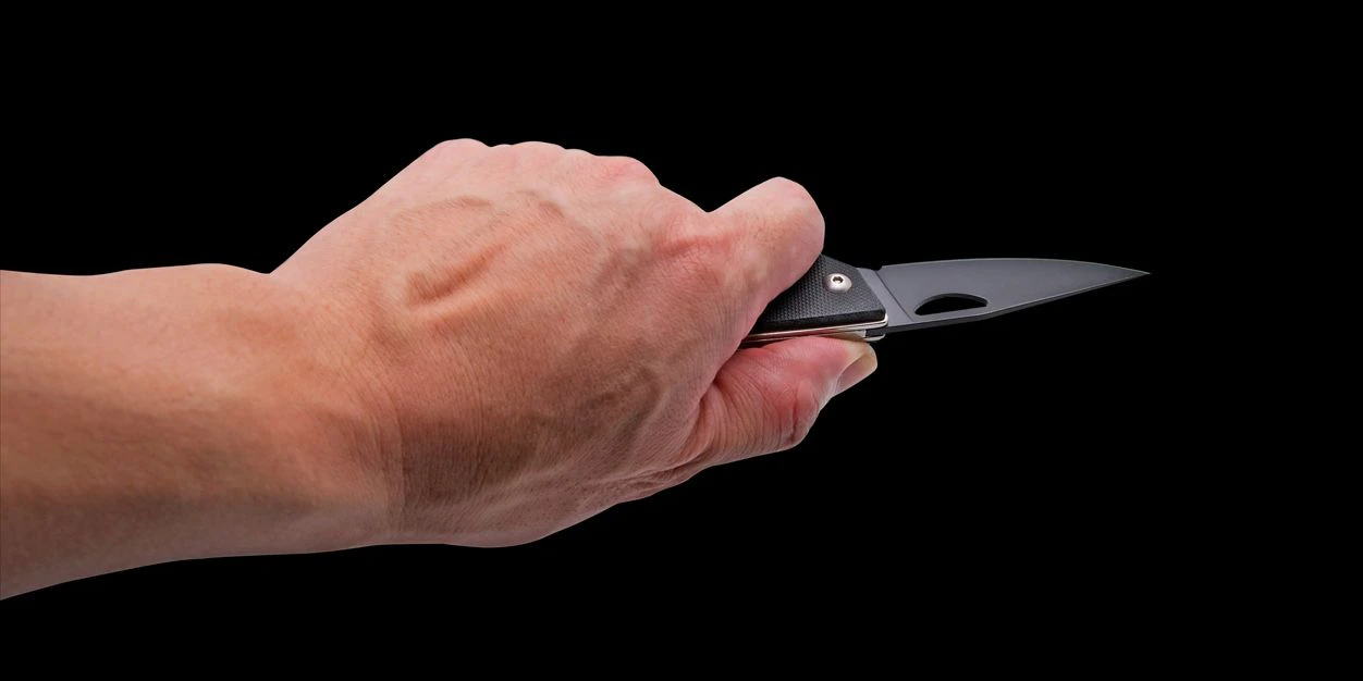 Hand holding Penknife Isolated on Black Background