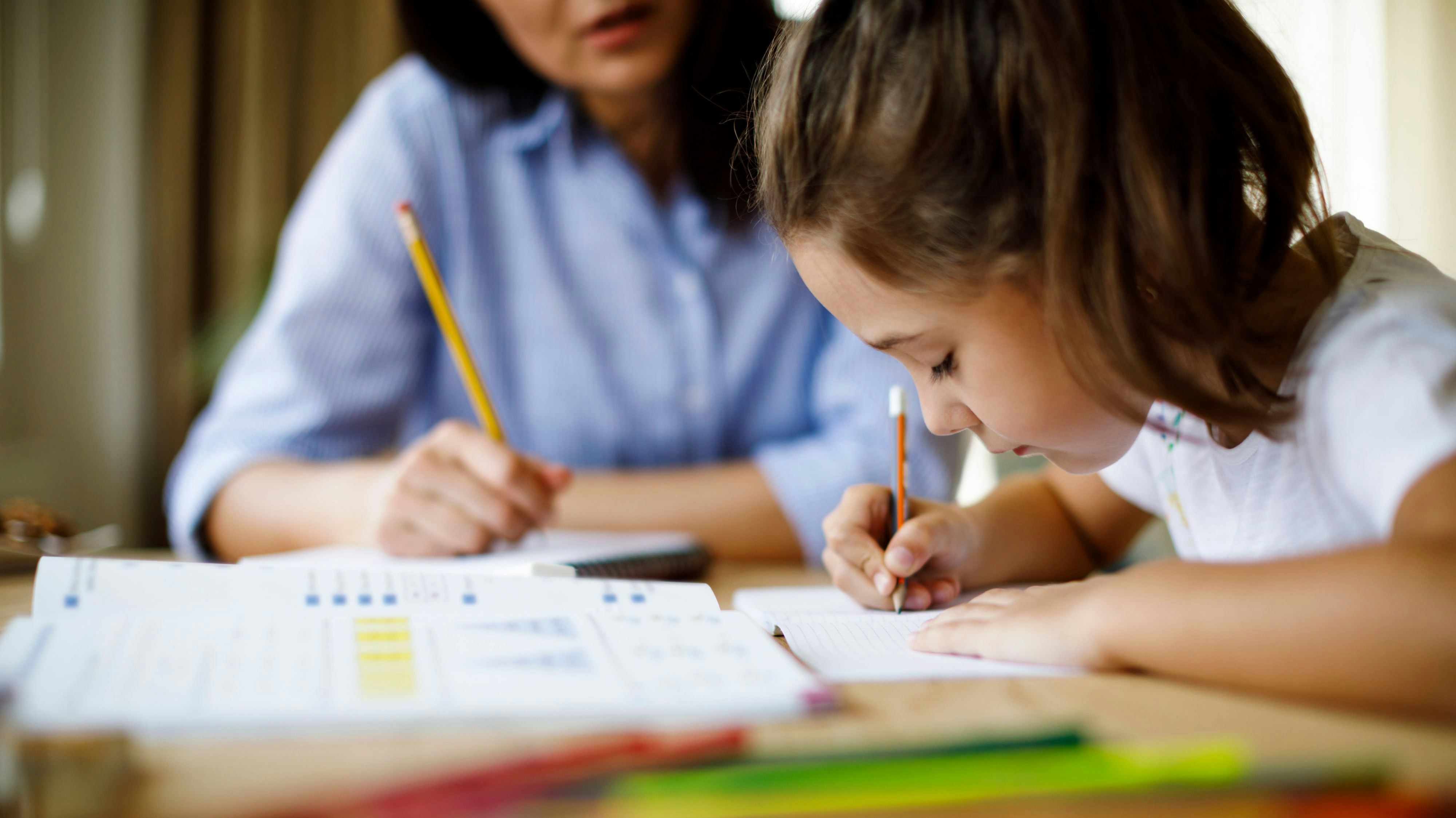 Mother helping daughter with homework