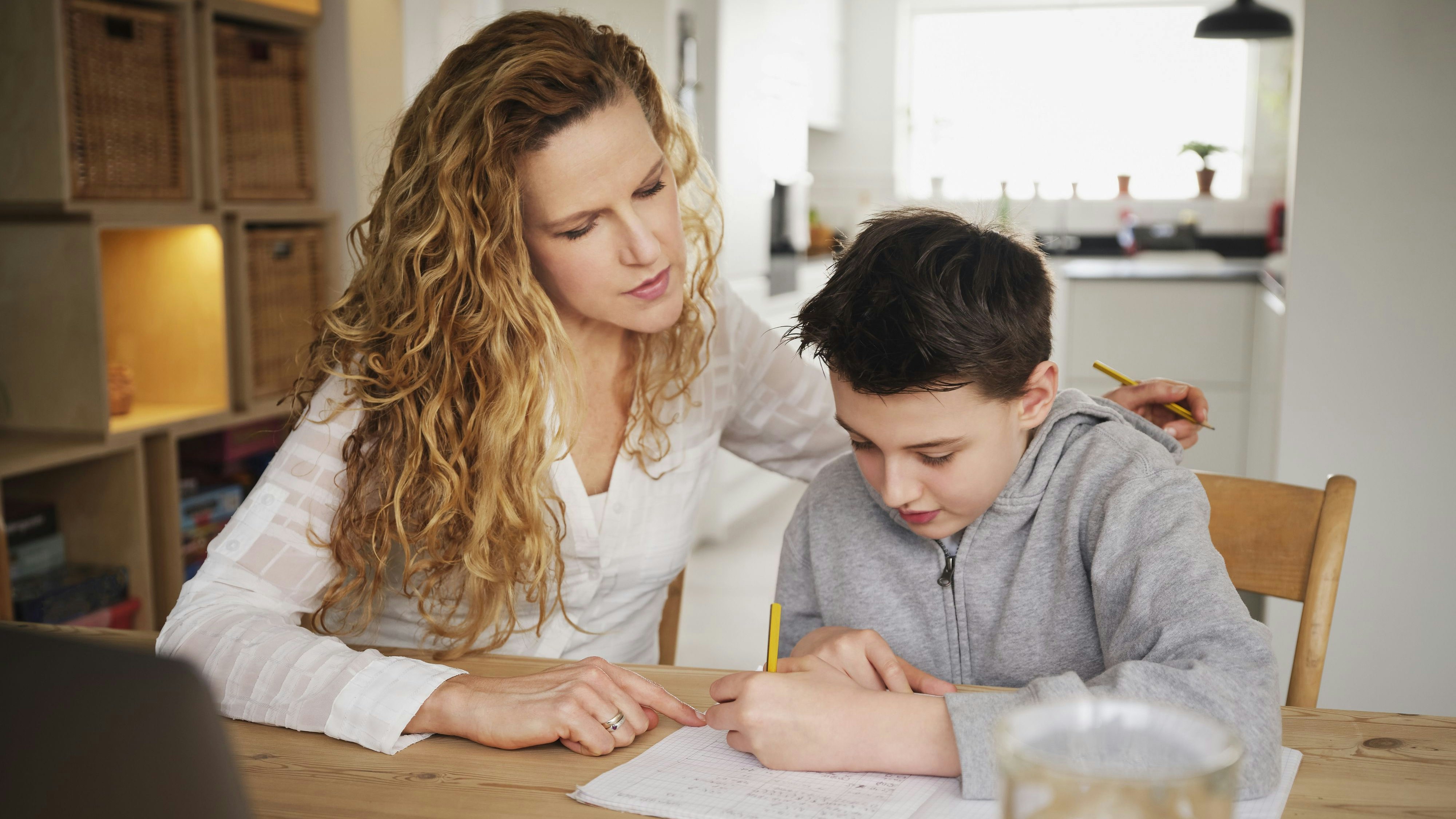 Mutter unterrichtet ihr Kind daheim.