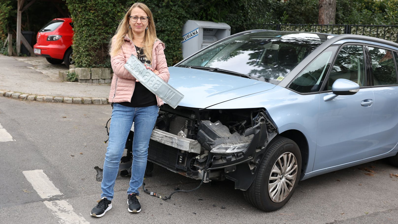 Katharina F. vor ihrem zerstörten Auto in Wien-Liesing.