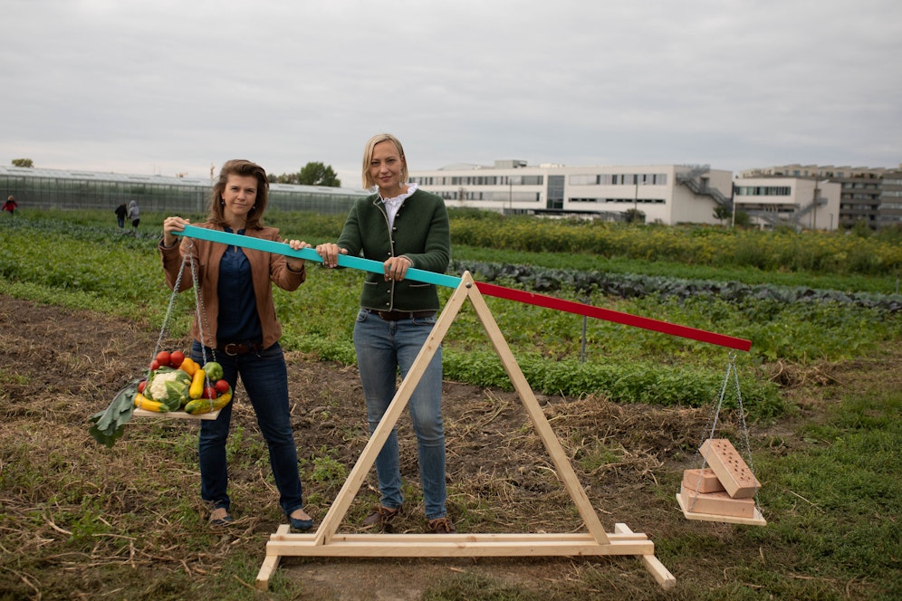 Die ÖVP Wien sieht die Wiener Landwirtschaft durch die Stadtentwicklung bedroht. Am Grundstück der Gärtnerei Ganger, der nun selbst der Verlust von Flächen droht, übten die Gemeinderätinnen Elisabeth Olischar (l.) und Caroline Hungerländer mittels türkis-roter Waage Kritik an der SPÖ.