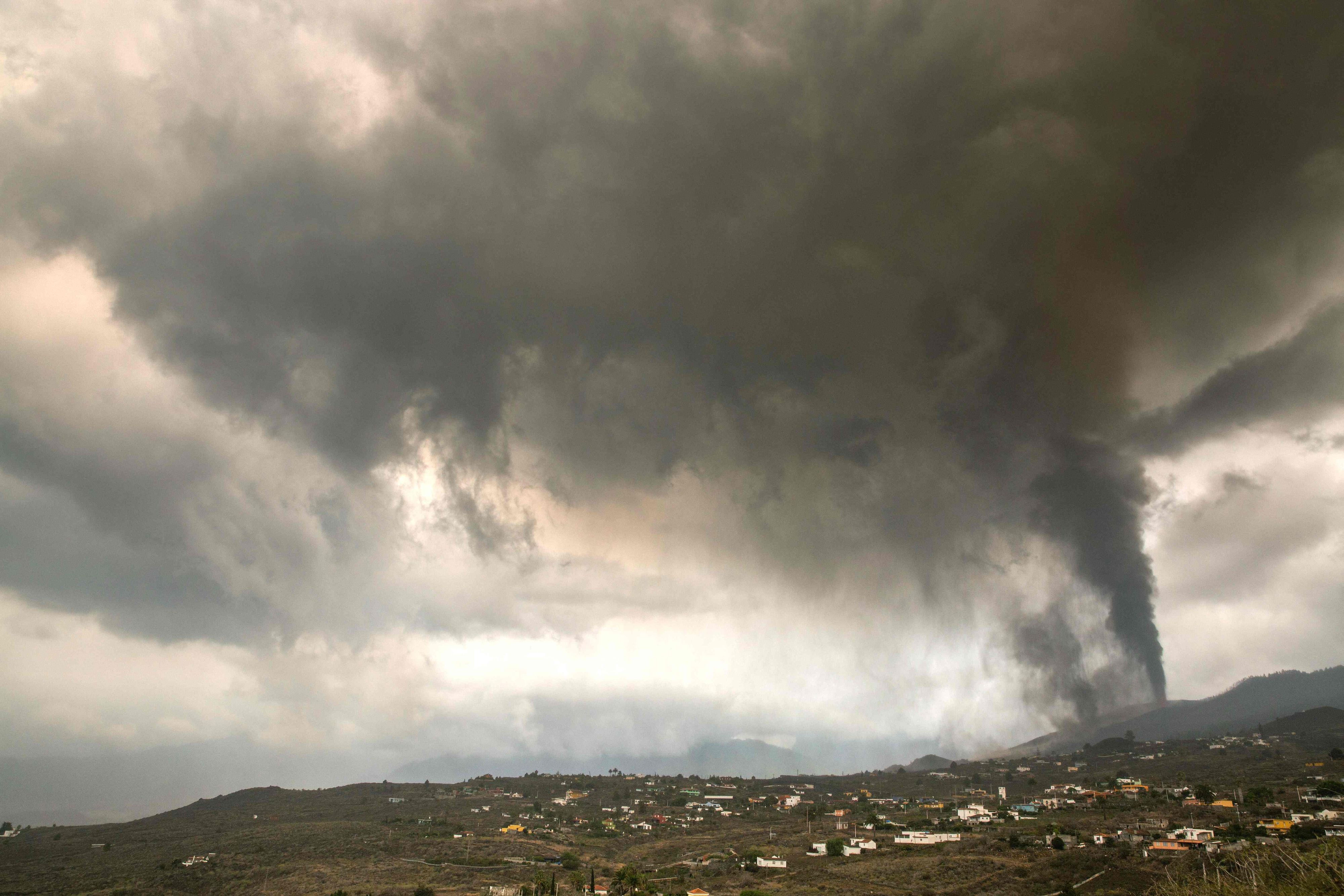 Download von www.picturedesk.com am 22.09.2021 (18:14).  A thick cloud of ash and gas from the volcano that went on erupting on September 19 in Cumbre Vieja mountain range, covers the Aridane valley as seen from Los Llanos de Aridane on the Canary Island of La Palma, on September 22, 2021. - The vast wall of molten lava creeping down the slopes of Spain's La Palma island has destroyed 320 buildings and over 154 hectares of land, Europe's volcano observatory said today. The Cumbre Vieja volcano, which erupted on September 19, 2021, straddles a ridge in the south of La Palma, one of seven islands that make up the Canary Islands, Spain's Atlantic archipelago which lies off the coast of Morocco. (Photo by DESIREE MARTIN / AFP) - 20210922_PD2854 - Rechteinfo: Rights Managed (RM) Nur für redaktionelle Nutzung! Werbliche Nutzung erfordert Freigabe: bitte schicken Sie uns eine Anfrage.
