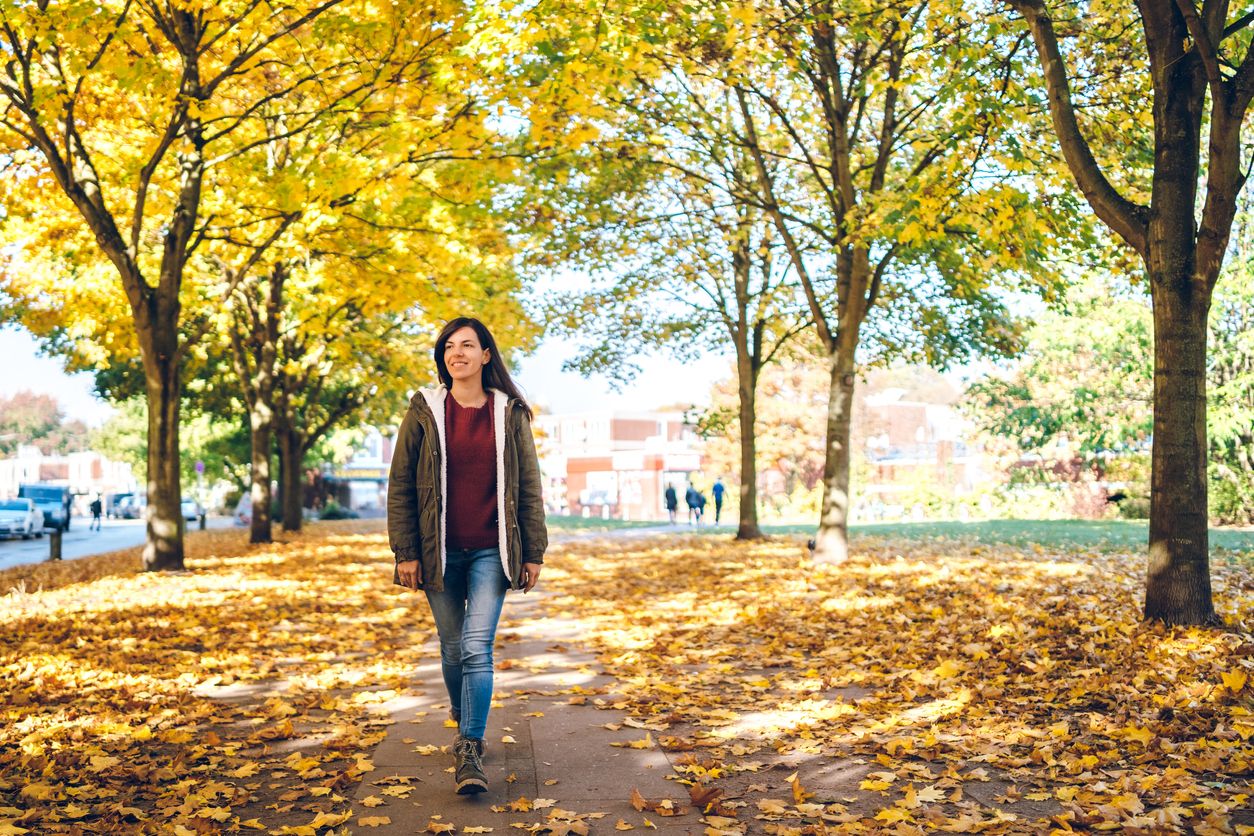 Young cute caucasian woman walking in a park. Autumn time.