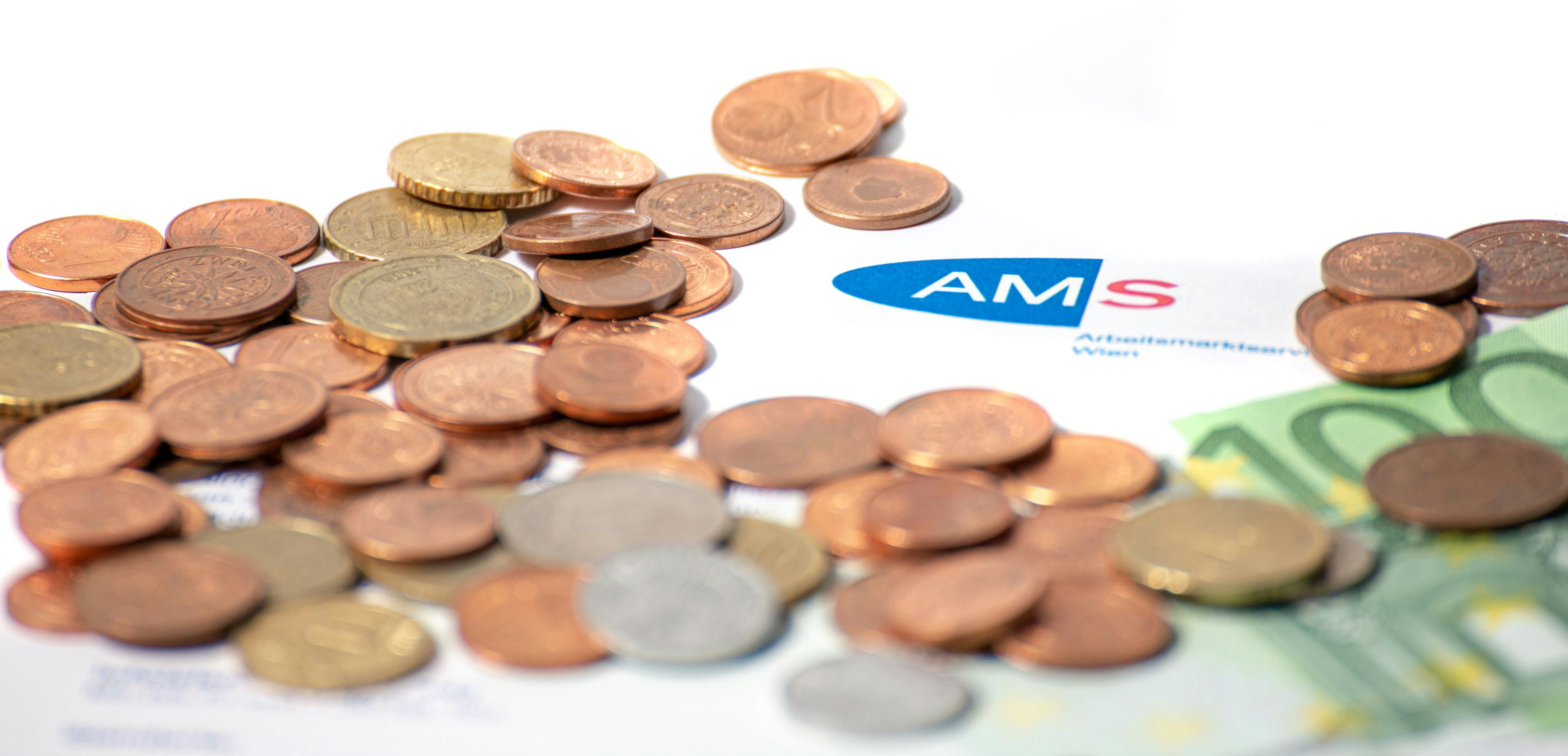 Download von www.picturedesk.com am 28.09.2021 (13:51).  AMS Formular mit AMS Logo sowie Schriftzug. Darauf liegen Geldmünzen sowie ein 100 Euro Geldschein. Wien, Österreich. Juni 2020 - 20200629_PD7926 - Rechteinfo: Rights Managed (RM)