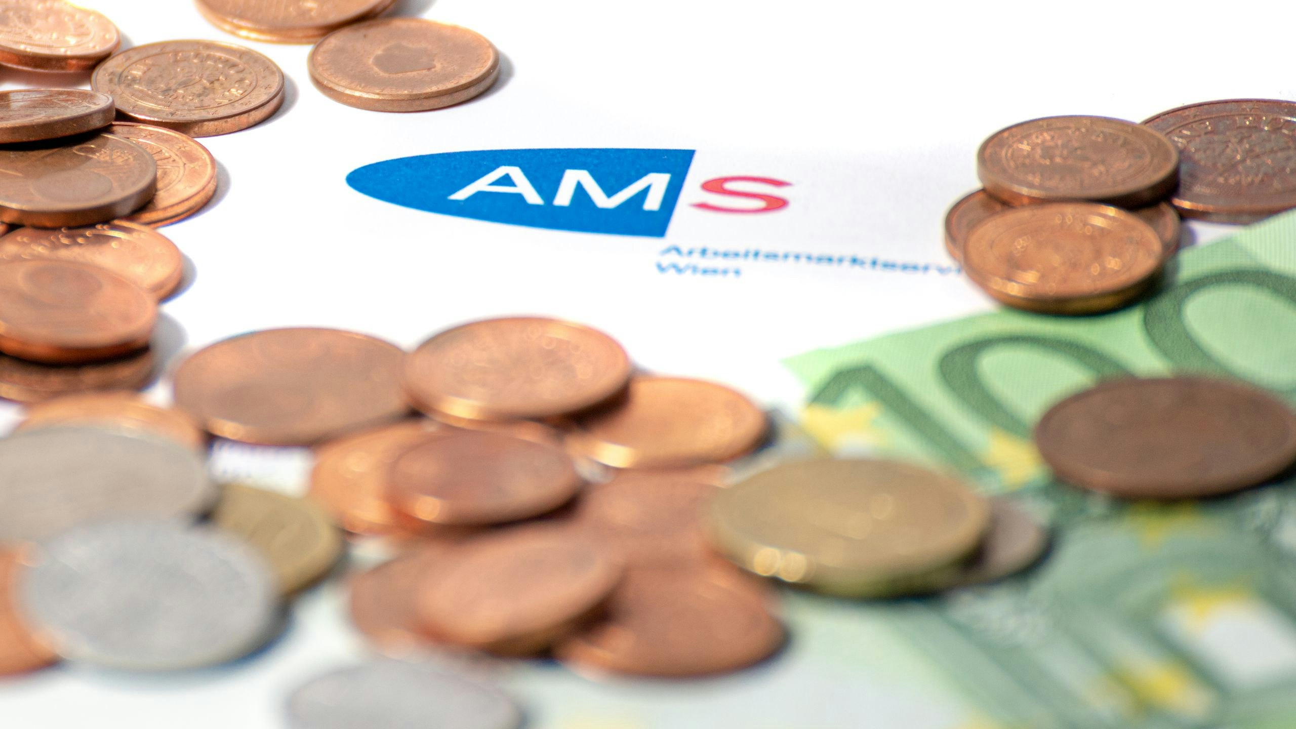 Download von www.picturedesk.com am 28.09.2021 (13:51).  AMS Formular mit AMS Logo sowie Schriftzug. Darauf liegen Geldmünzen sowie ein 100 Euro Geldschein. Wien, Österreich. Juni 2020 - 20200629_PD7926 - Rechteinfo: Rights Managed (RM)
