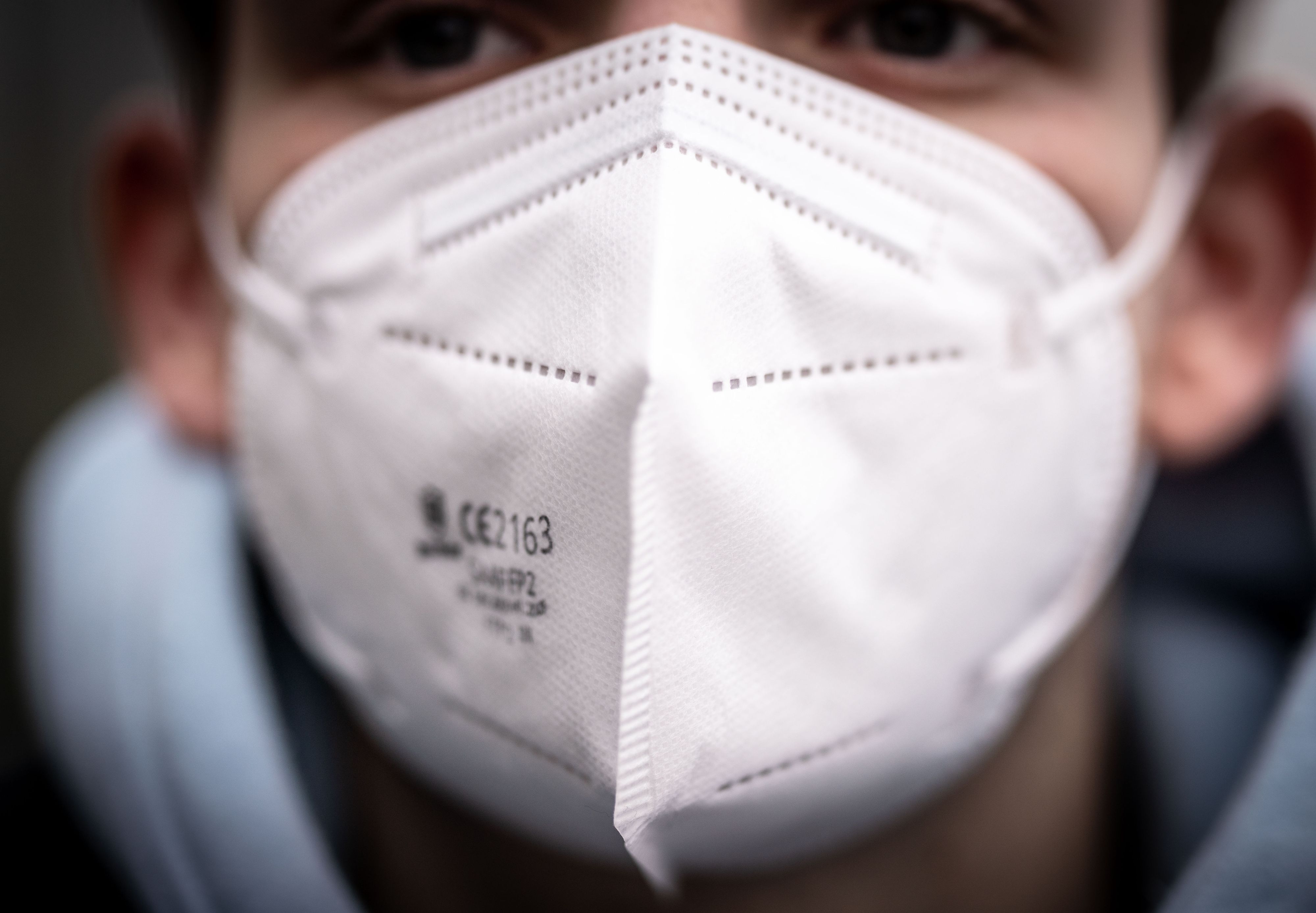 Download von www.picturedesk.com am 18.01.2021 (14:50).  18 January 2021, Hessen, Frankfurt/Main: ILLUSTRATION - A young man wears an FFP2 mask. To protect against the coronavirus, more people from risk groups are to receive FFP2 masks financed by the federal government than initially planned. According to a comparison with health insurance data, 34.1 million instead of 27 million citizens are to be sent vouchers for twelve FFP2 masks in the next few days. Photo: Frank Rumpenhorst/dpa - 20210118_PD2226 - Rechteinfo: Rights Managed (RM)