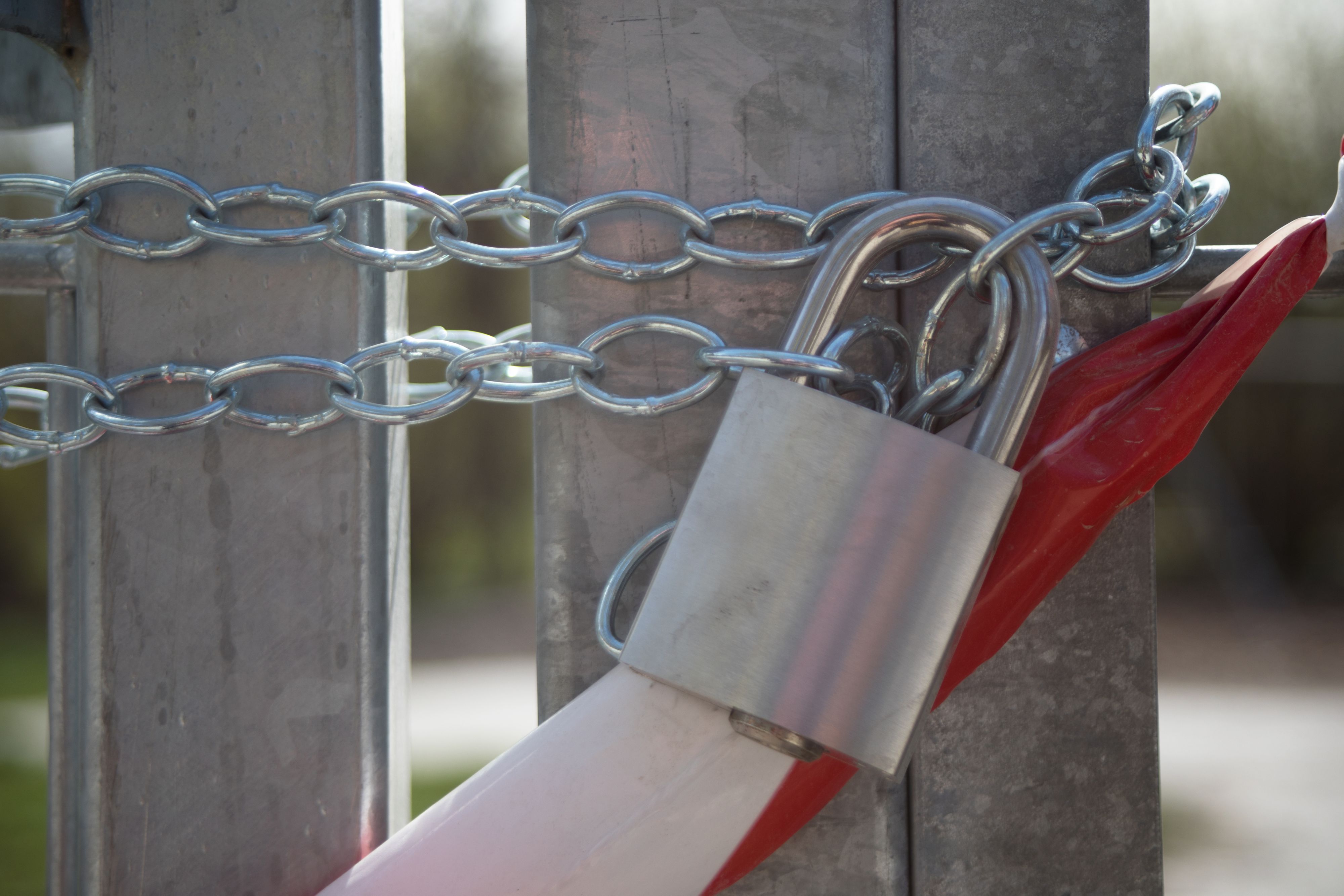 Eine mit Kette, Vorhängeschloss und Absperrband geschlossener Kinderspielplatz in Wien während dem ersten Lockdown im März 2020